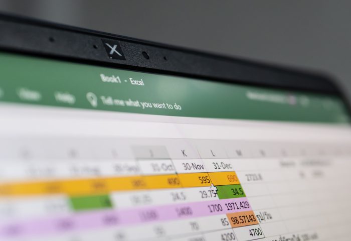 Close-up of a laptop screen displaying a spreadsheet with highlighted cells and numeric data.